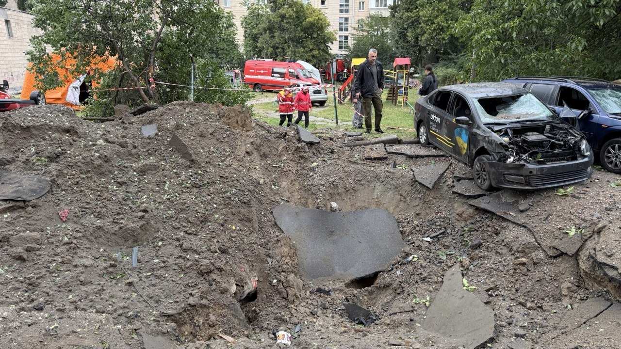 Вирва та пошкоджені автомобілі біля житлового будинку в Києві після атаки
