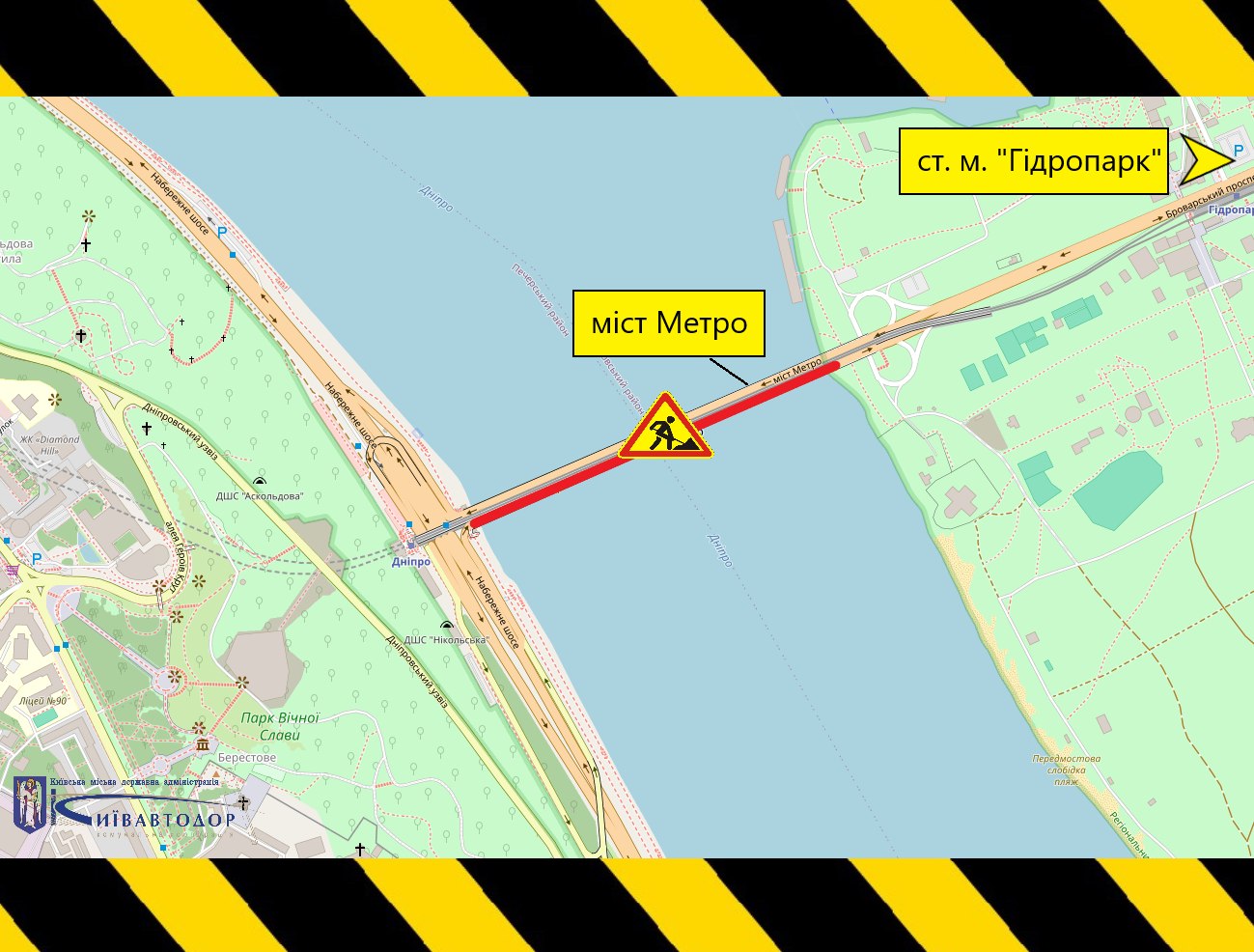Схематична карта із позначенням ділянки ремонту мосту Метро через Дніпро в Києві. Червоним кольором виділено частину мосту в напрямку станції метро «Гідропарк», де проводитимуть дорожні роботи. На схемі також розміщено знак дорожніх робіт, стрілку в напрямку станції метро «Гідропарк» і підпис «міст Метро». Фоном є карта місцевості із берегами Дніпра, транспортними шляхами та зеленими зонами. Верхній і нижній краї зображення оформлені чорно-жовтими попереджувальними смугами.